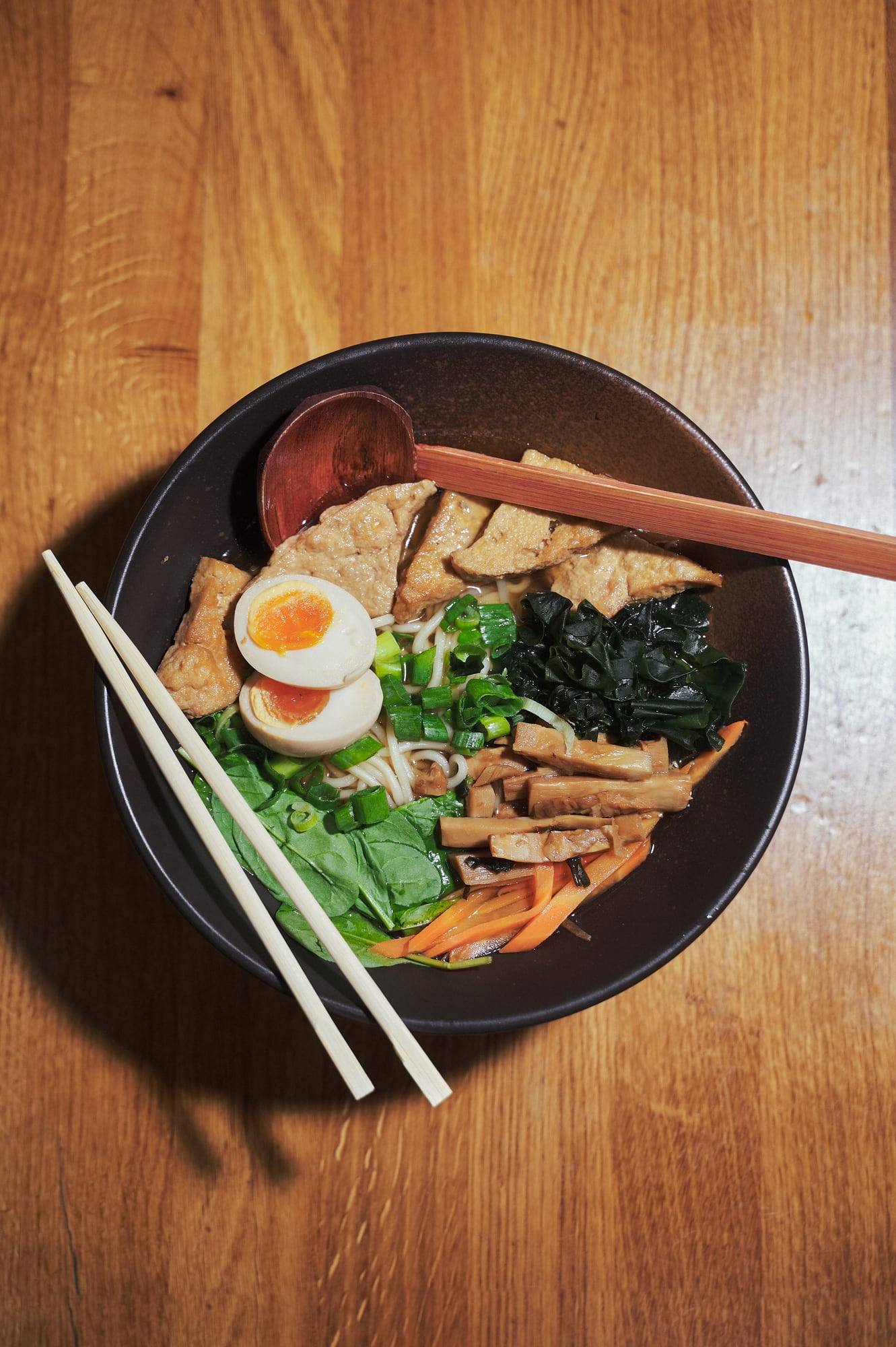 Ramen-Schüssel mit Ei, Spinat und Stäbchen von oben