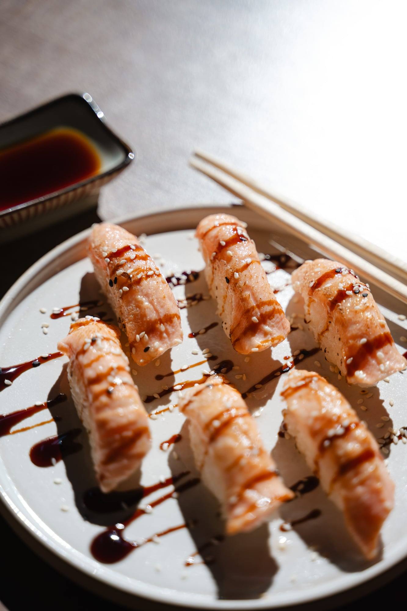 Sushi-Röllchen mit Teriyaki-Sauce auf einem grauen Teller