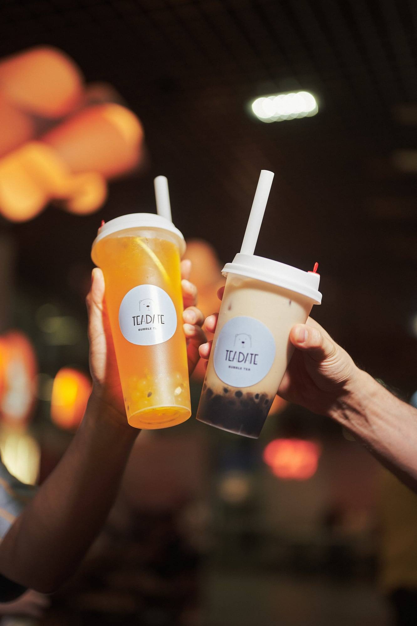 Zwei Bubble Teas werden in einem dunklen Lokal angestoßen
