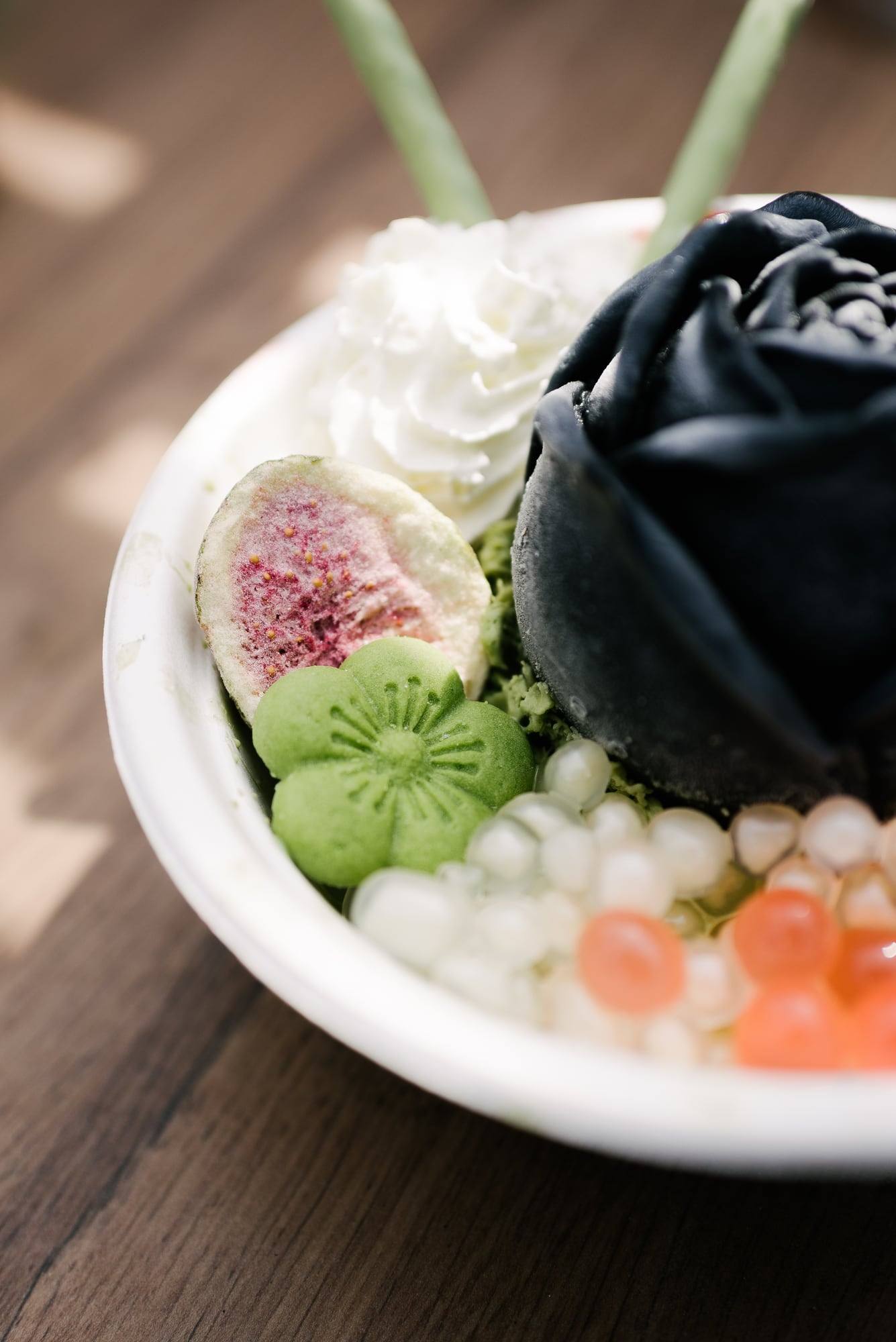 Nahaufnahme einer Bowl mit Feige, Matcha und schwarzer Eis-Rose