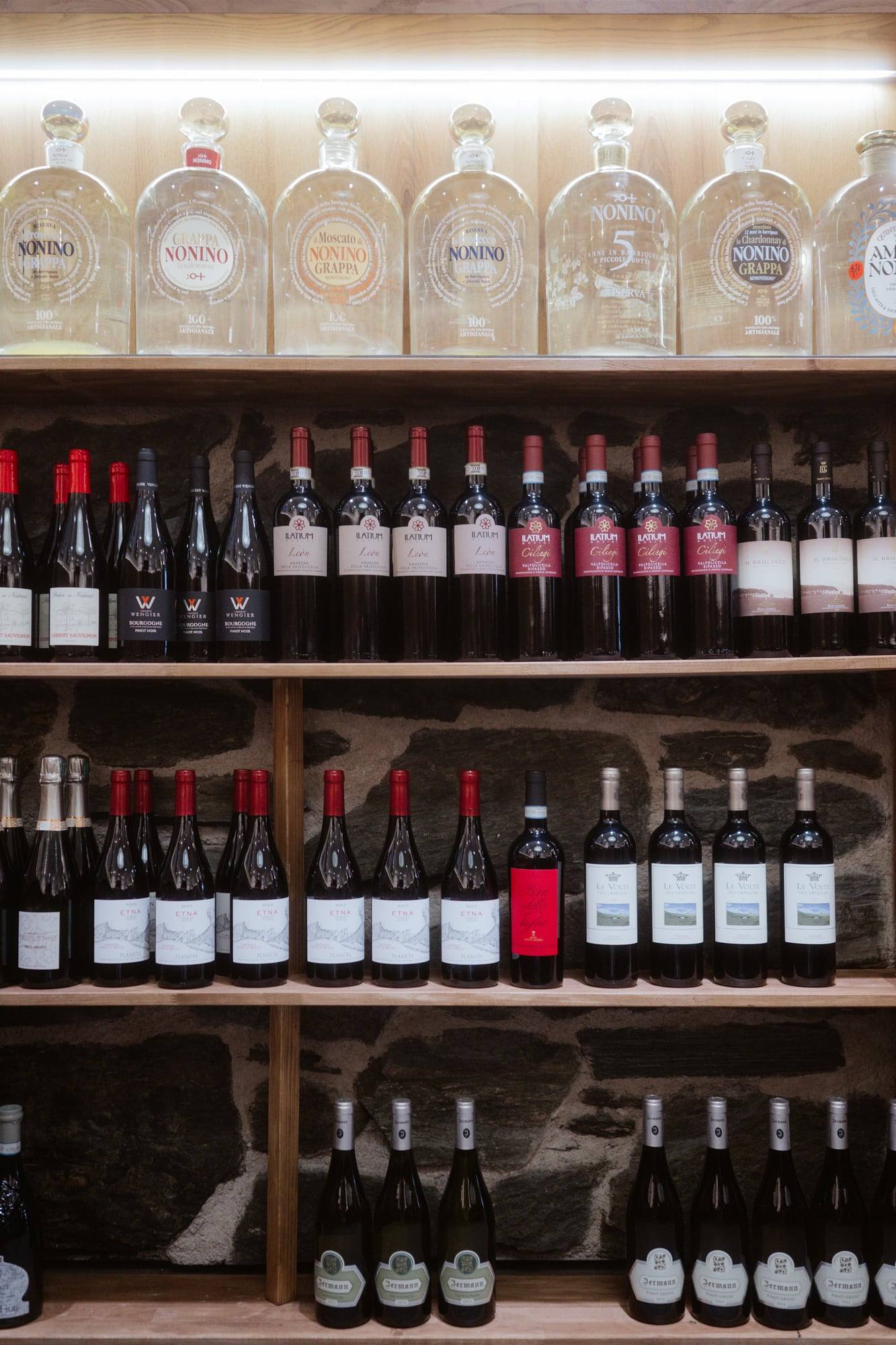 Weinregal mit Flaschen und Grappa im Ristorante