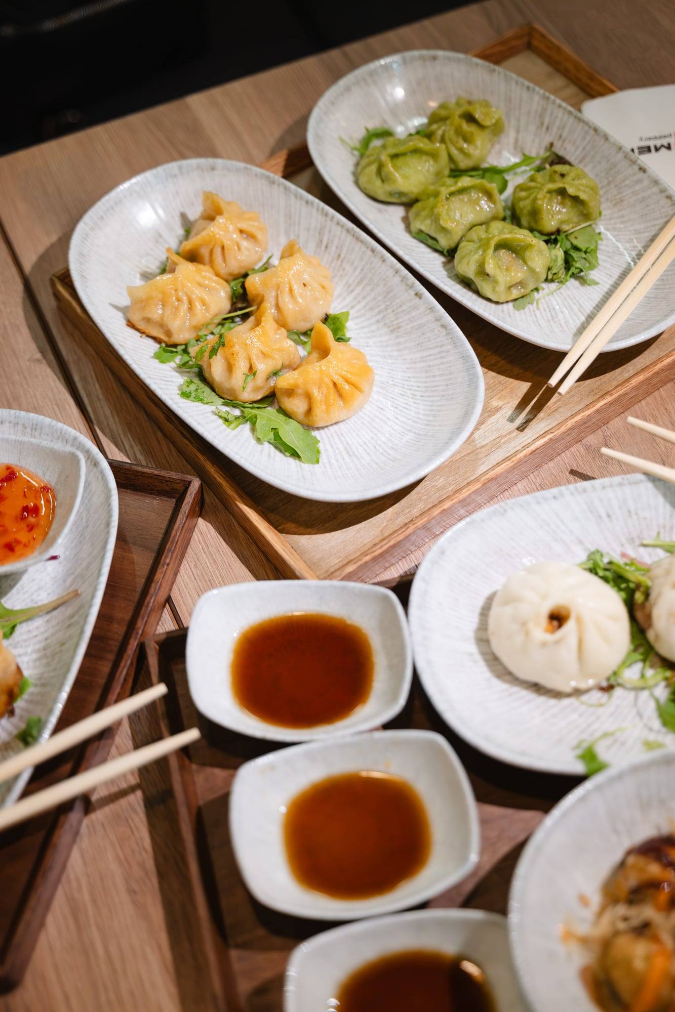 Dumplings mit Dip-Saucen auf einem Holztablett