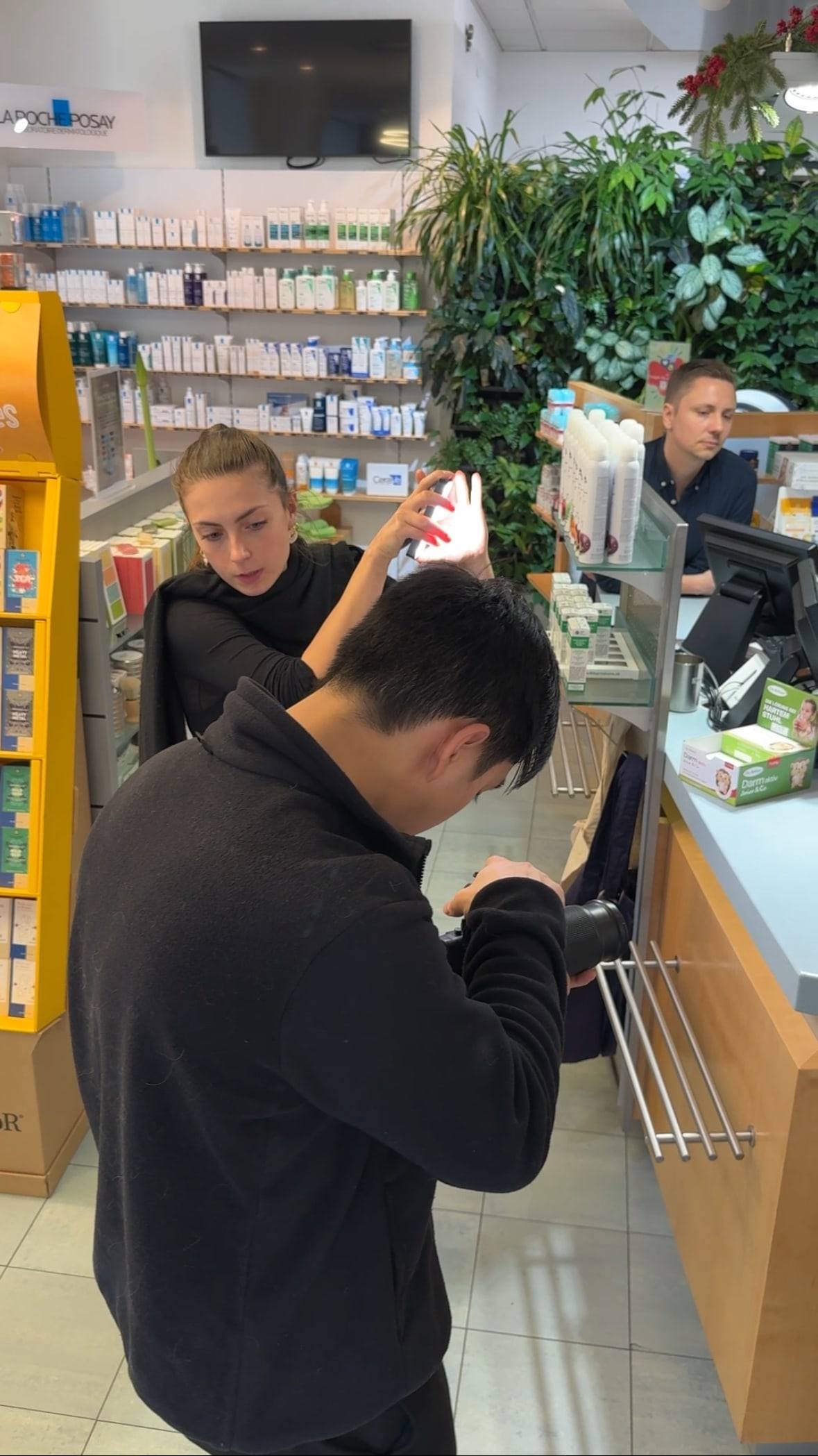 Videograf filmt eine Apothekerin hinter dem Verkaufspult einer Wiener Apotheke