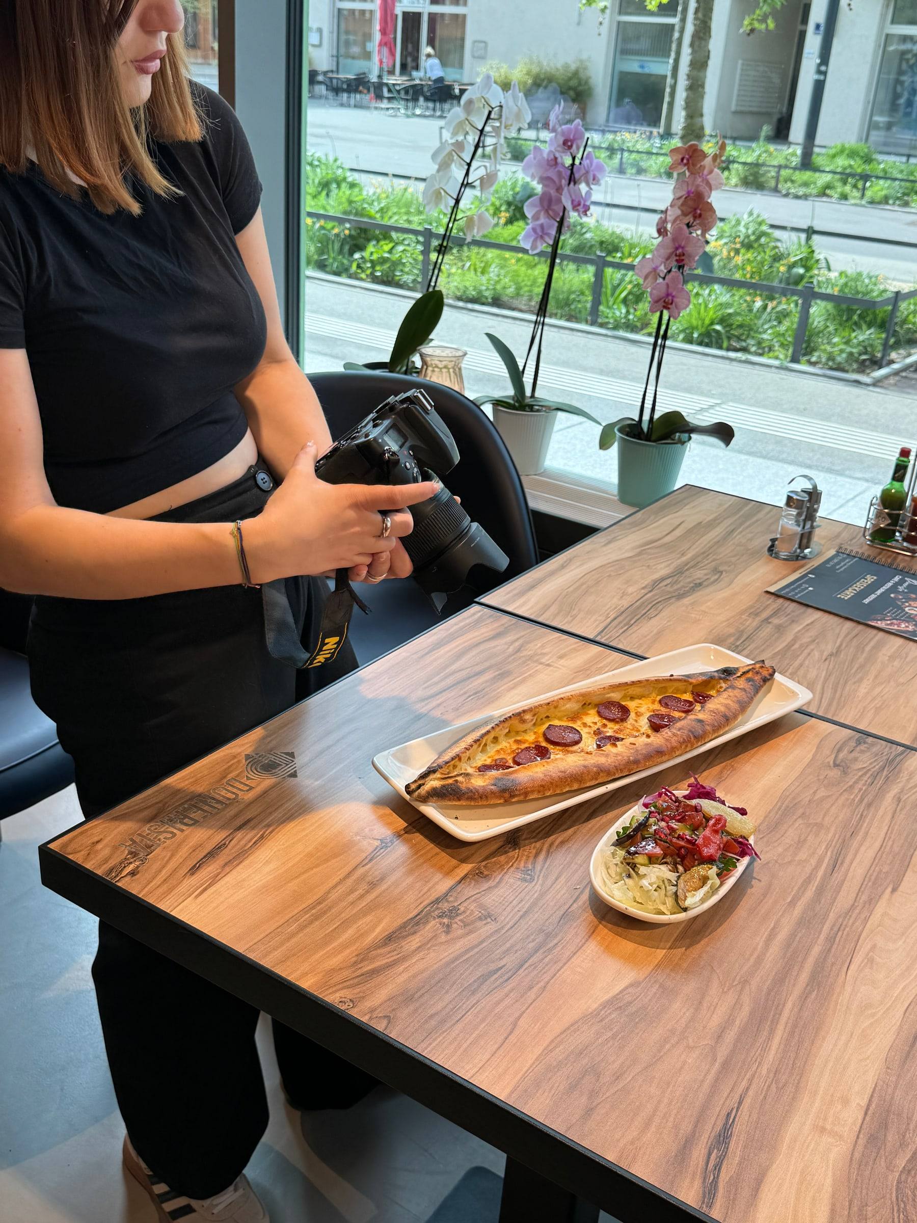 Fotografin bereitet bei Dönerista das Foto einer Pide am Holztisch vor