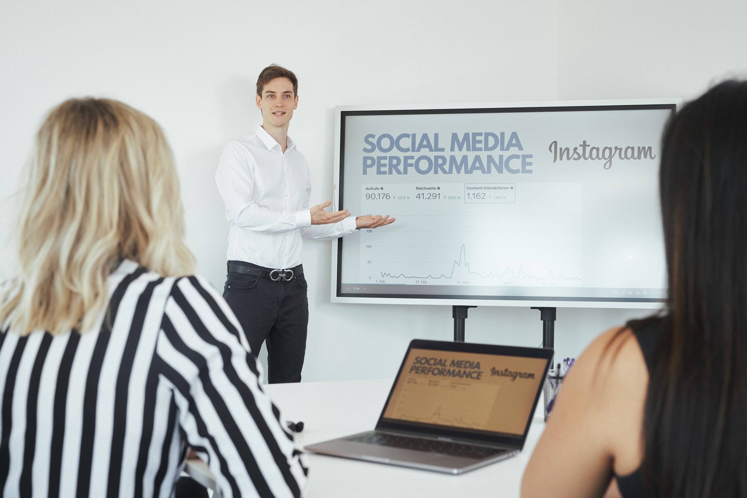 Beniamino Häfner präsentiert auf einem Bildschirm die Social-Media-Auswertung eines Kunden
