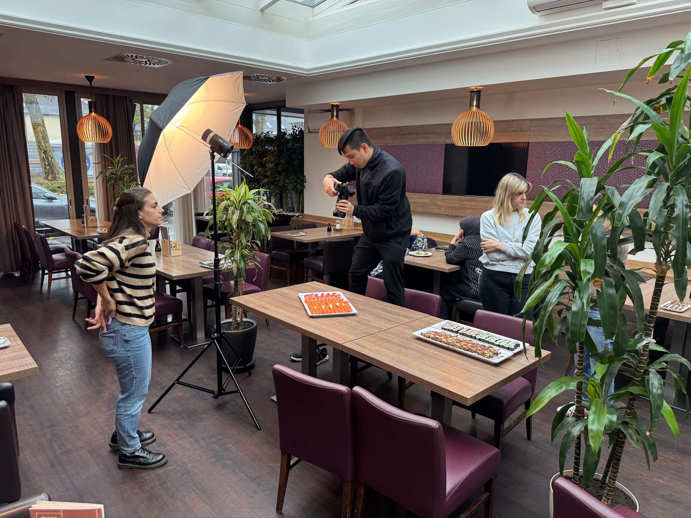 Drehtag in einem Wiener Restaurant: Fotograf mit Schirmleuchte, Stativ und angerichtetem Tisch